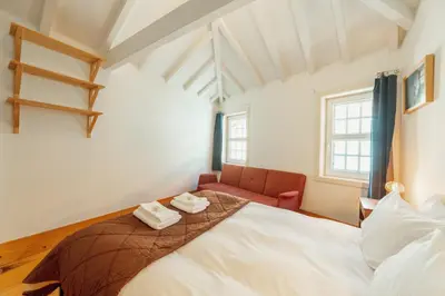 a bedroom with a bed and a red chair at Historical Duplex by Hosty in Porto