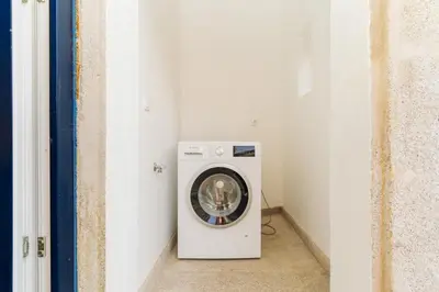 a washer and dryer in a room at Charming Studio w/ Private Garden in St. Catarina in Porto