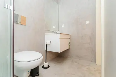 a bathroom with a white toilet and a sink at Charming Studio w/ Private Garden in St. Catarina in Porto