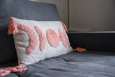 a pillow on a couch with a pink thread at GuestReady - Welcoming place in Porto in Porto