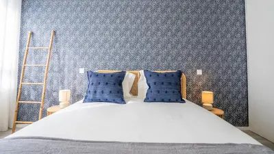 a bedroom with a bed with blue wallpaper at TrindadeFlat w AC by LovelyStay in Porto