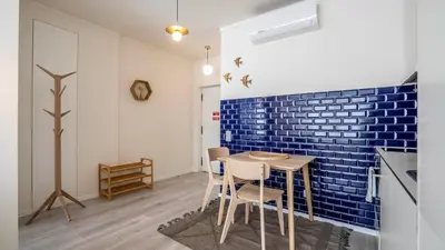a kitchen with a table and a blue brick wall at TrindadeFlat w AC by LovelyStay in Porto