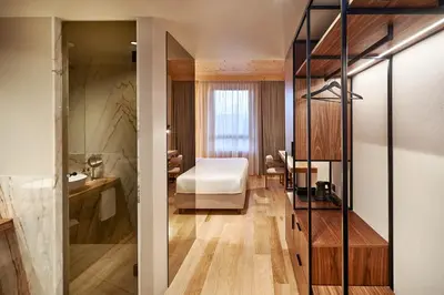 a hotel room with a bed and a bathroom at The Log Porto Hotel by Piamonte Hotels in Porto