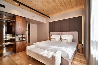 a bedroom with a large white bed and a chair at The Log Porto Hotel by Piamonte Hotels in Porto
