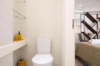 a small bathroom with a toilet and a bed at St Ildefonso 03 in Porto