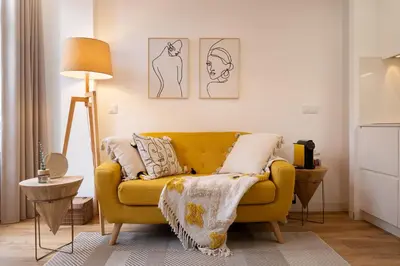 a living room with a yellow couch with pillows at St Ildefonso 04 in Porto
