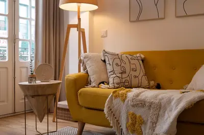a living room with a yellow couch and a lamp at St Ildefonso 04 in Porto