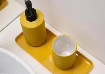 a yellow tray with a bottle and a cup on it at St Ildefonso 04 in Porto