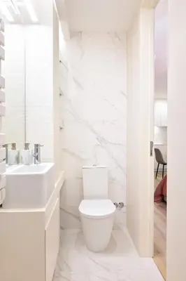 a white bathroom with a toilet and a sink at St Ildefonso 05 in Porto