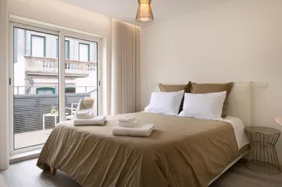 a bedroom with a large bed with towels on it at St Ildefonso 06 in Porto
