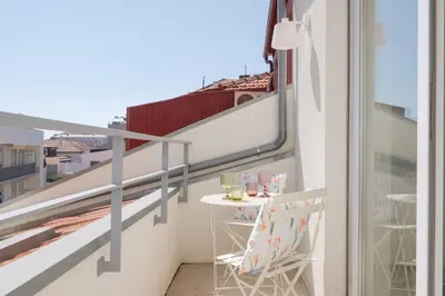 a balcony with a table and chairs on a building at St Ildefonso 06 in Porto