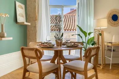 a dining room with a table and chairs and a window at Casa Flores - in Historical Center in Porto