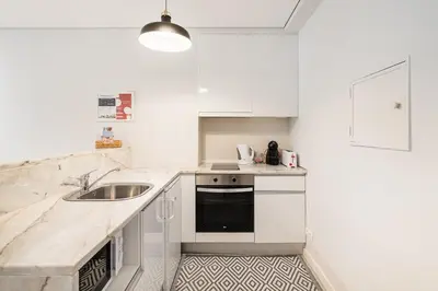 a kitchen with white cabinets and a sink at GuestReady - Homely stay in Porto in Porto