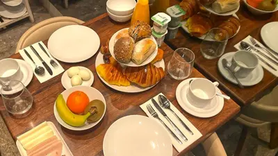 a wooden table topped with plates and bowls of food at CHARM by YoursPorto in Vila Nova de Gaia