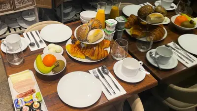 a wooden table topped with plates and bowls of food at CHARM by YoursPorto in Vila Nova de Gaia