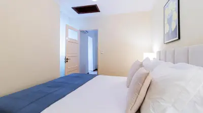 a white bedroom with a large bed with white pillows at 2BR Home near Douro River by LovelyStay in Vila Nova de Gaia