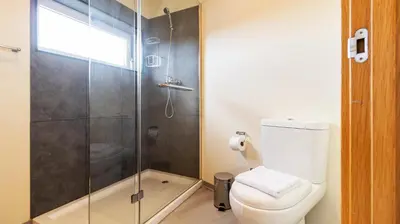 a bathroom with a toilet and a glass shower at 2BR Home near Douro River by LovelyStay in Vila Nova de Gaia