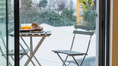 a table with drinks and a chair on a balcony at 3T Charming apartment in Boavista in Porto