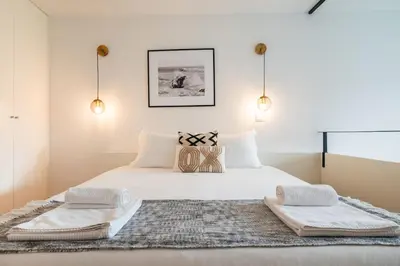a bedroom with a white bed with two towels on it at Classy Garden in Porto