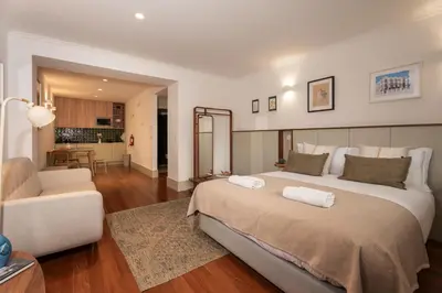 a bedroom with a large bed and a living room at Casa Priorado - Charming View City Center in Porto