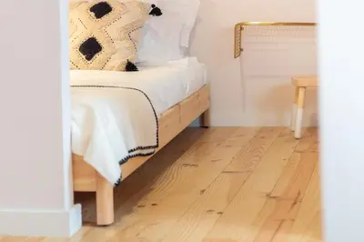 a bedroom with a bed with white sheets and a wooden floor at Olive Tree House by LovelyStay in Porto
