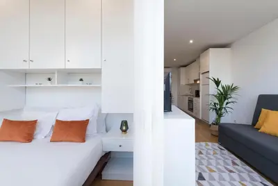a bedroom with white cabinets and a bed with orange pillows at Apartment Boavista Roundabout by Sweet Porto in Porto