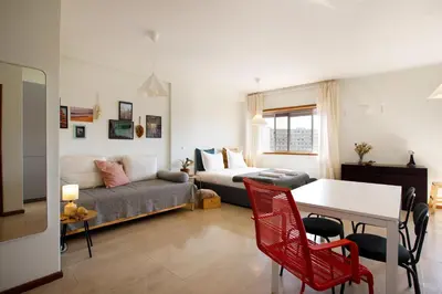 a kitchen and living room with a table and chairs at Casa Guilhermina, Sunny Studio with Balcony in Porto