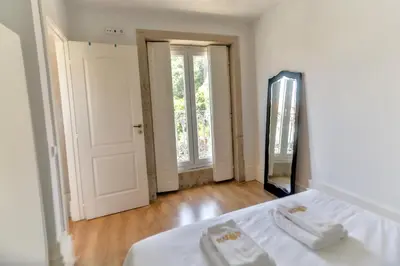 a white bedroom with a bed and a mirror at Cedofeita Downtown Nightlife by PCH in Porto