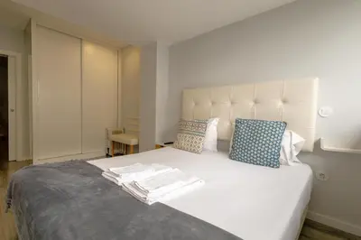 a bedroom with a white bed and a tv at Happy Downtown Apartments by PCH in Porto