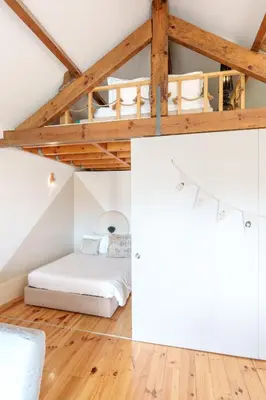 an attic bedroom with a bed and wooden ceilings at VIVA Boho Chic in Porto