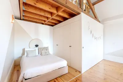 a small bedroom with white walls and wooden ceilings at VIVA Boho Chic in Porto