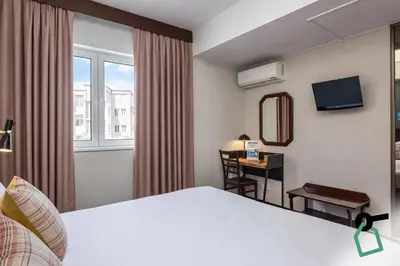 a hotel room with a bed and a desk at HOTIDAY Room Collection - Oporto in Porto