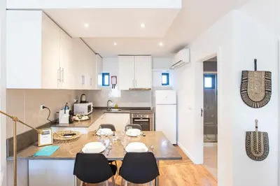 a kitchen with white cabinets and a table and chairs at FLH Porto Central TownHouse in Porto