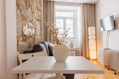 a white table with a vase on it in a living room at Cozee Bonjardim in Porto