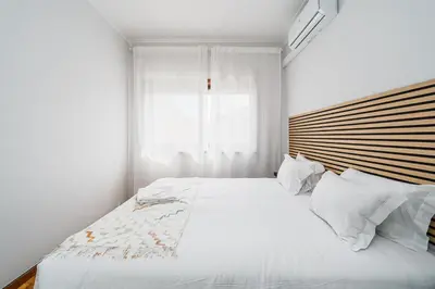 a bedroom with a large white bed with a wooden headboard at Happy Mountain in Porto