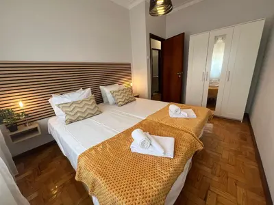 a bedroom with a large white bed with towels on it at Happy Mountain in Porto