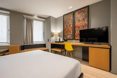 a hotel room with a bed and a desk with a television at Descobertas Boutique Hotel by Aspasios in Porto