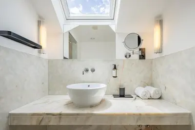 a bathroom with a white sink and a skylight at Descobertas Boutique Hotel by Aspasios in Porto