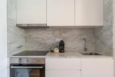 a kitchen with white cabinets and a sink at Topazio Apartment by Porto Stories in Porto