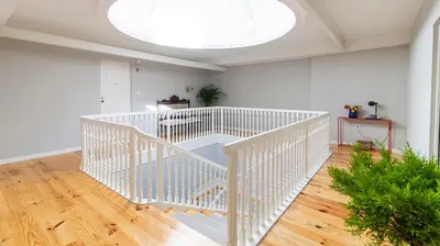 a white spiral staircase in a room with a window at Carmo Apartamentos in Porto
