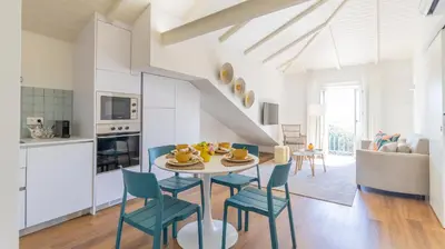 a kitchen and dining room with a table and chairs at Carmo Apartamentos in Porto