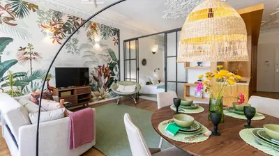 a living room with a table and chairs and a television at Carmo Apartamentos in Porto
