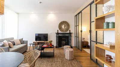 a living room with a couch and a fireplace at Carmo Apartamentos in Porto