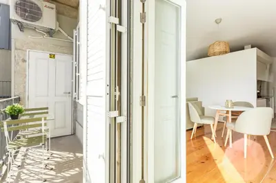 a kitchen and dining room with white walls and a table at Home M apartments in Porto