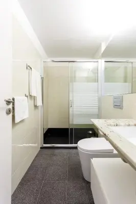 a bathroom with a shower and a toilet and a sink at Home M apartments in Porto