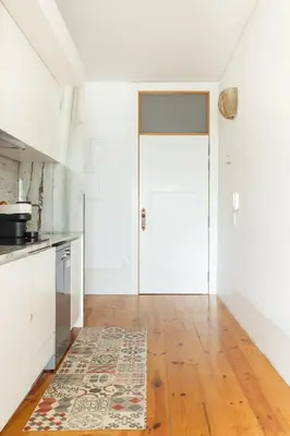 an empty kitchen with a white door and a rug at Home M apartments in Porto