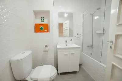 a white bathroom with a toilet and a shower at Cedofeita Flat by Hosty in Porto