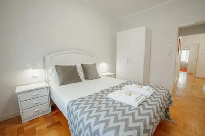 a white bedroom with a bed with towels on it at Cedofeita Flat by Hosty in Porto