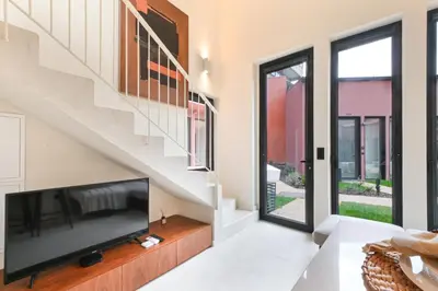 a living room with a flat screen tv sitting under a staircase at ON Apartments - Cozy - Free Parking & Pet Friendly in Porto