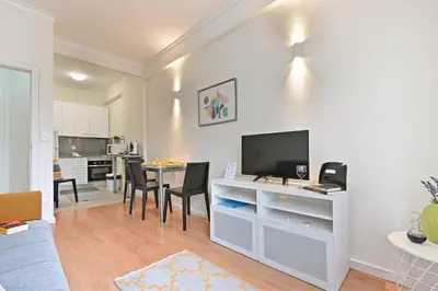 a living room with a television and a table with chairs at Breeze Oporto Boavista Terrace in Porto
